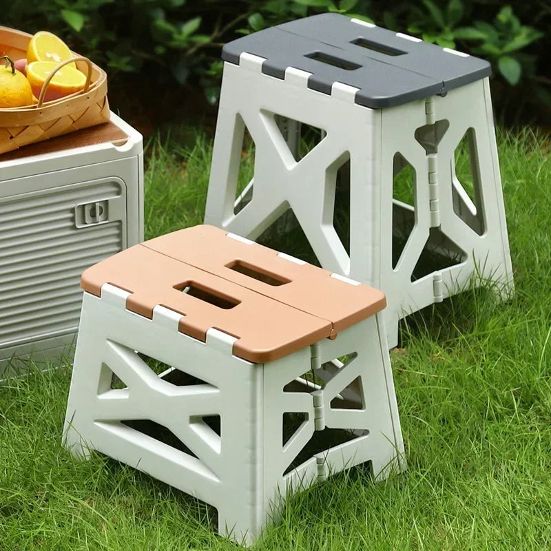 Plastic foldable chair for home use with beige and gray tops on green grass outdoor setting
