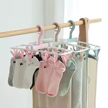 Clarify.pk wide shoulder clothes hanger with multiple clips holding gloves and pants on wooden rod