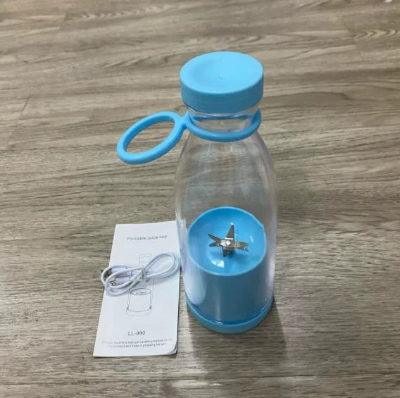 Clarify.pk portable electric juicer blender in blue with USB charging cable and user manual on wooden surface