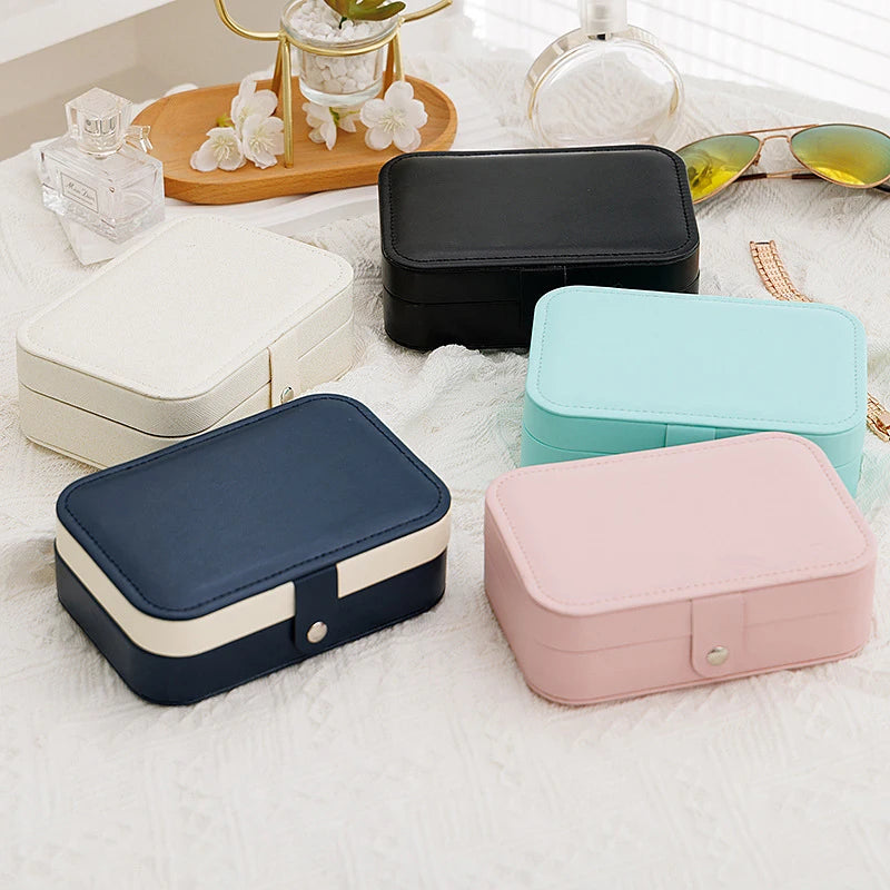 Clarify.pk portable jewelry storage box in black white blue pink and mint colors on white surface