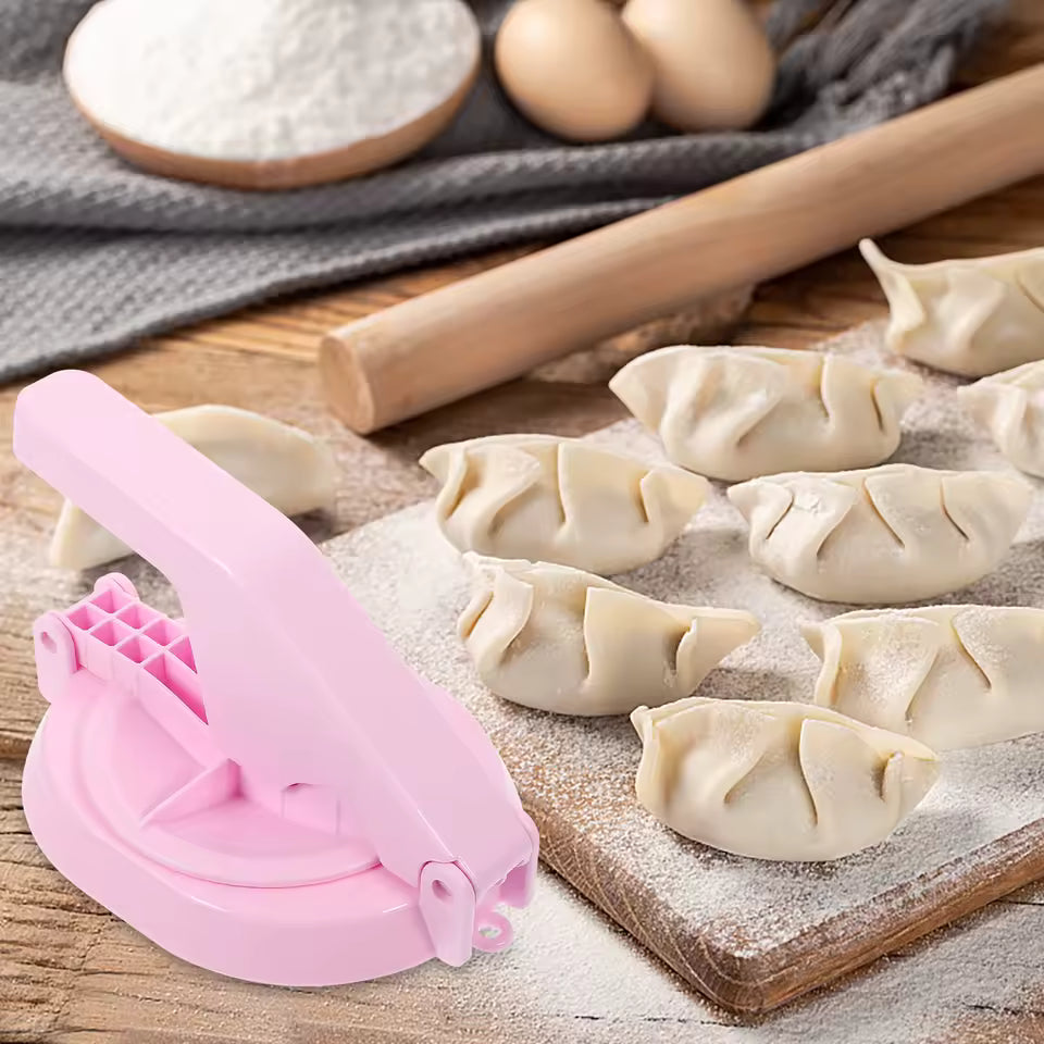 Portable kitchen dumpling press in pink with freshly made dumplings on a wooden board