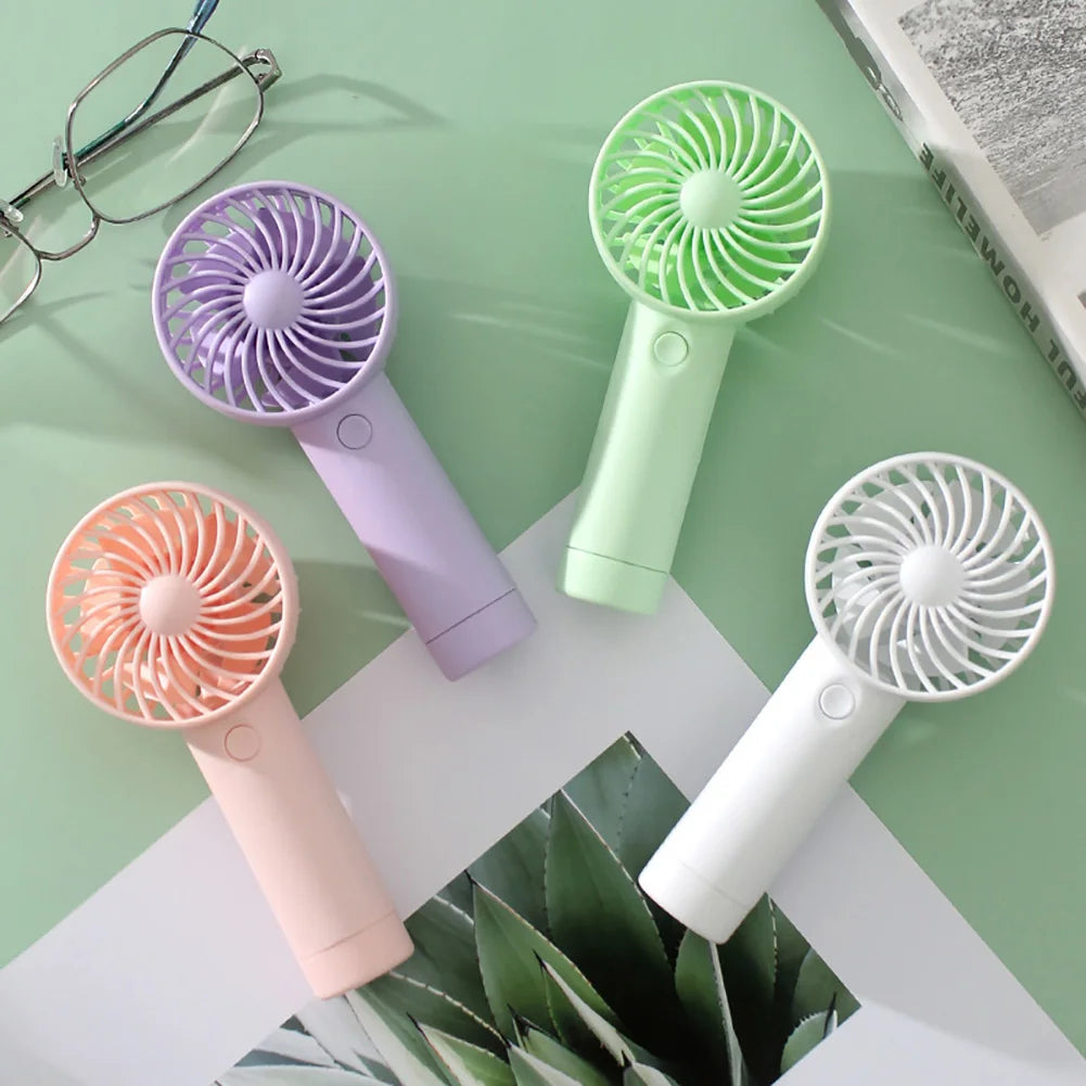 Clarify.pk portable mini fan USB rechargeable in purple green white and peach colors on a table
