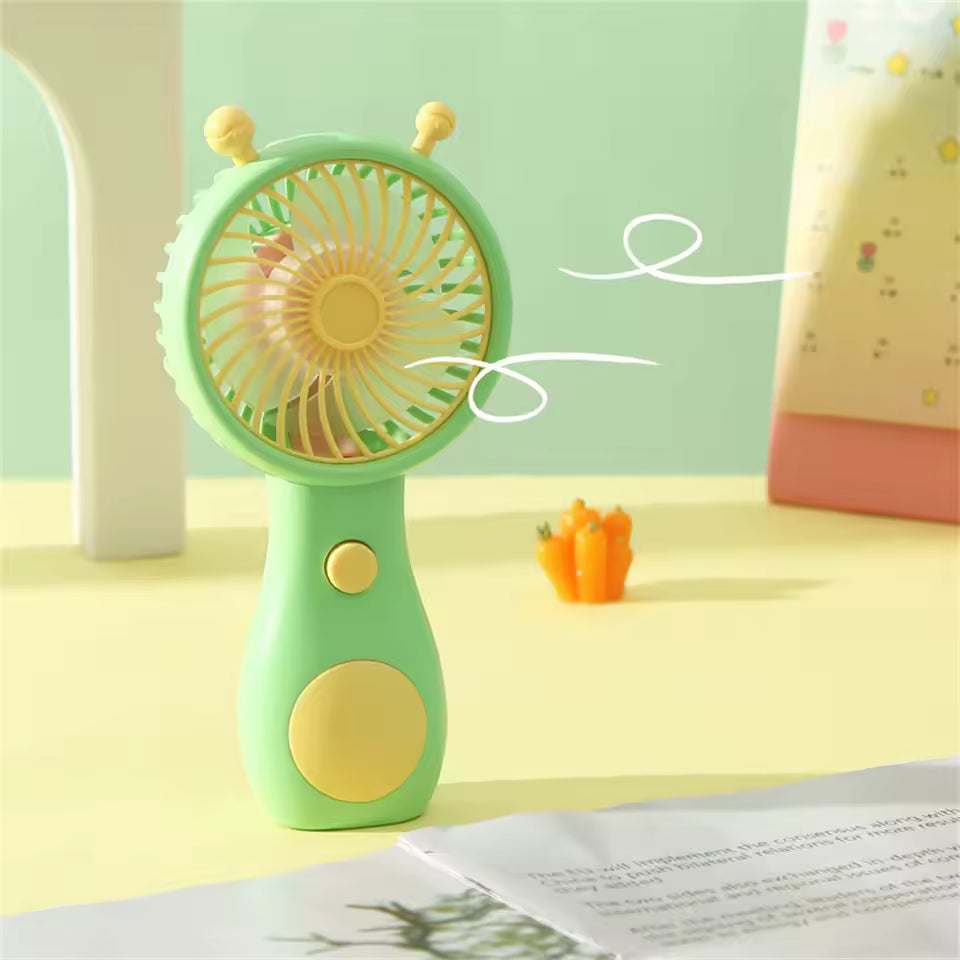 Green portable mini fan USB rechargeable with yellow blades and button on desk blowing air