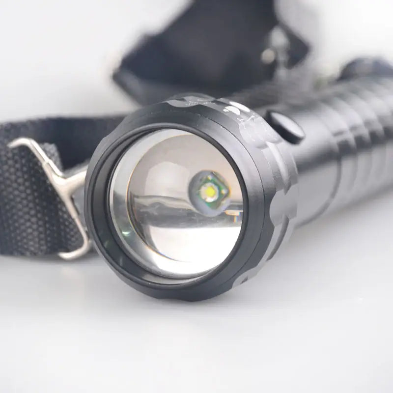 Compact black portable outdoor flashlight for camping with a wrist strap and LED bulb