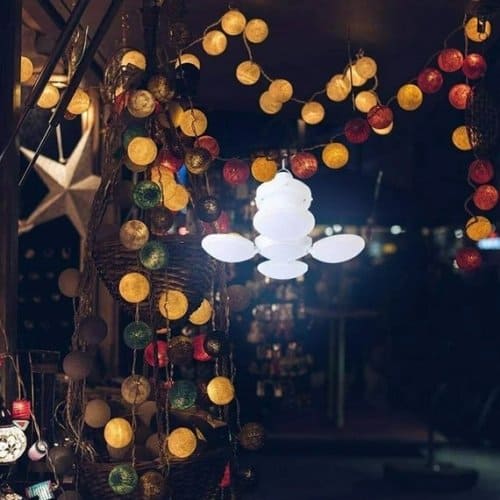 Clarify.pk portable rechargeable led lantern glowing brightly among decorative round string lights indoors