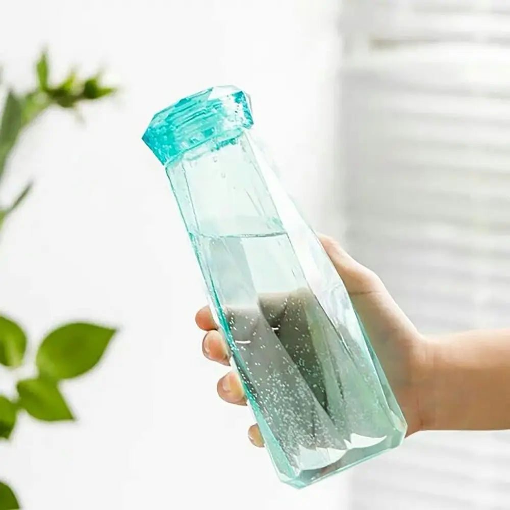 Transparent blue portable sport drink bottle held in hand with water inside and modern design
