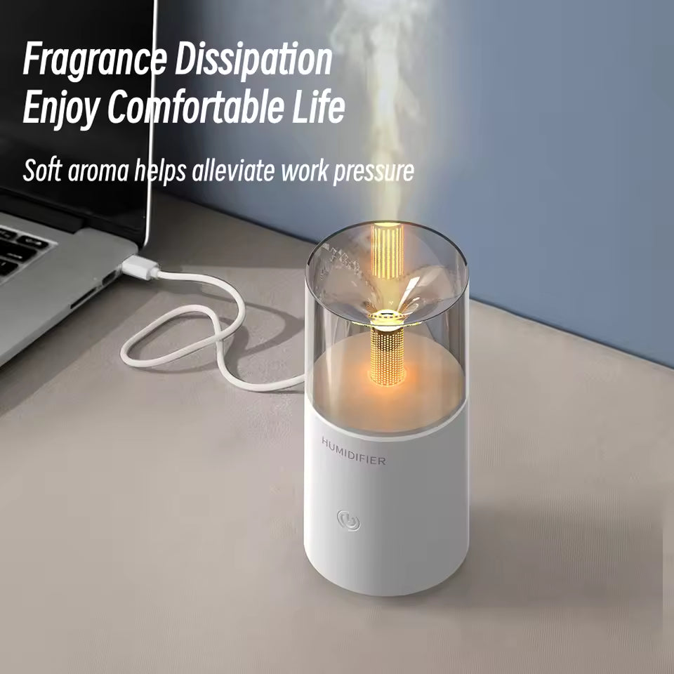 Portable USB aroma humidifier emitting soft mist connected to a laptop on a desk