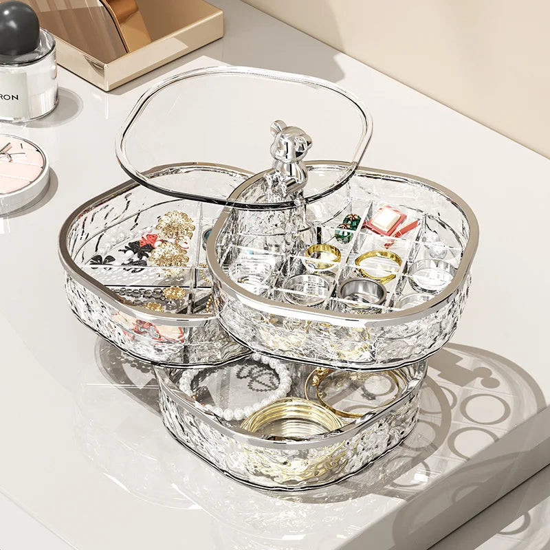 High-end jewelry storage box with clear compartments showcasing rings earrings and bracelets on a white surface