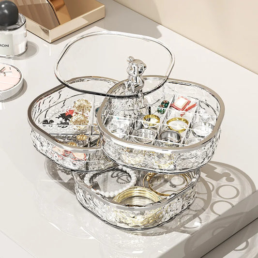 High-end jewelry storage box with clear compartments showcasing rings earrings and bracelets on a white surface