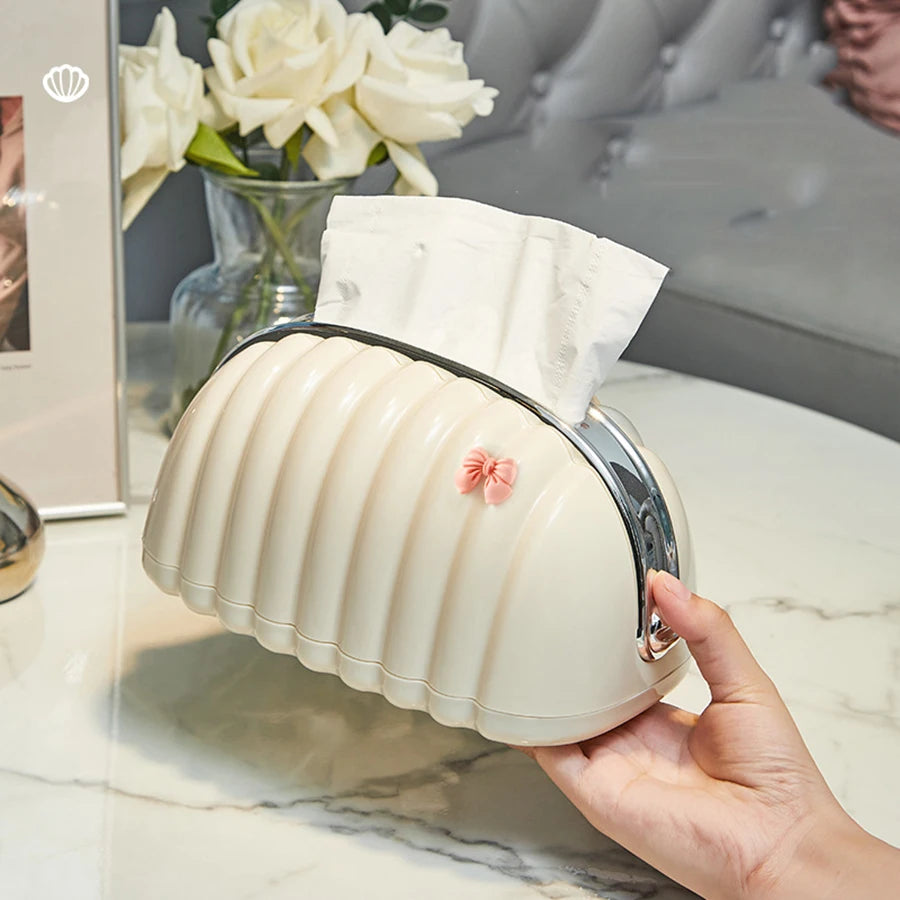 Cream-colored Premium Plastic Tissue Holder with ribbed design and small pink bow being held on marble table