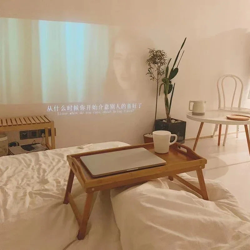Premium quality natural bamboo table with foldable legs holding a laptop and cup on a bed