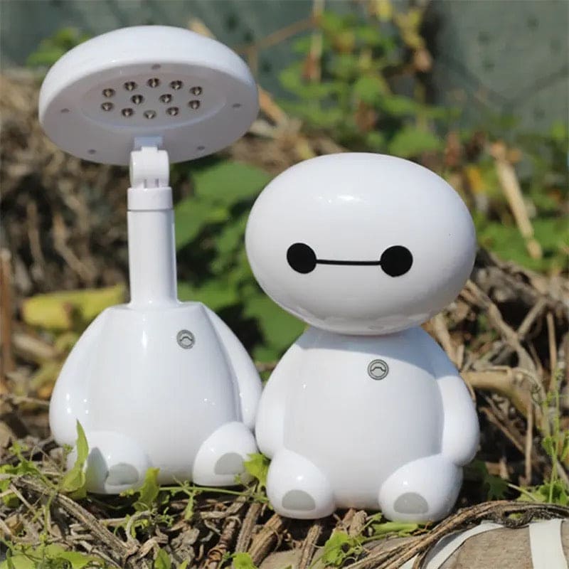 White rechargeable study lamp with eye protection shaped like a cute robot sitting outdoors on grass