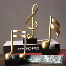 Clarify.pk resin musical note decor 3 pieces set in gold finish displayed on books