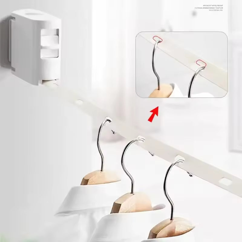 White retractable clothesline mounted on wall with hangers holding white shirts