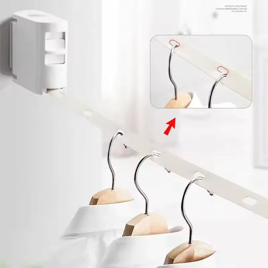 White retractable clothesline mounted on wall with hangers holding white shirts