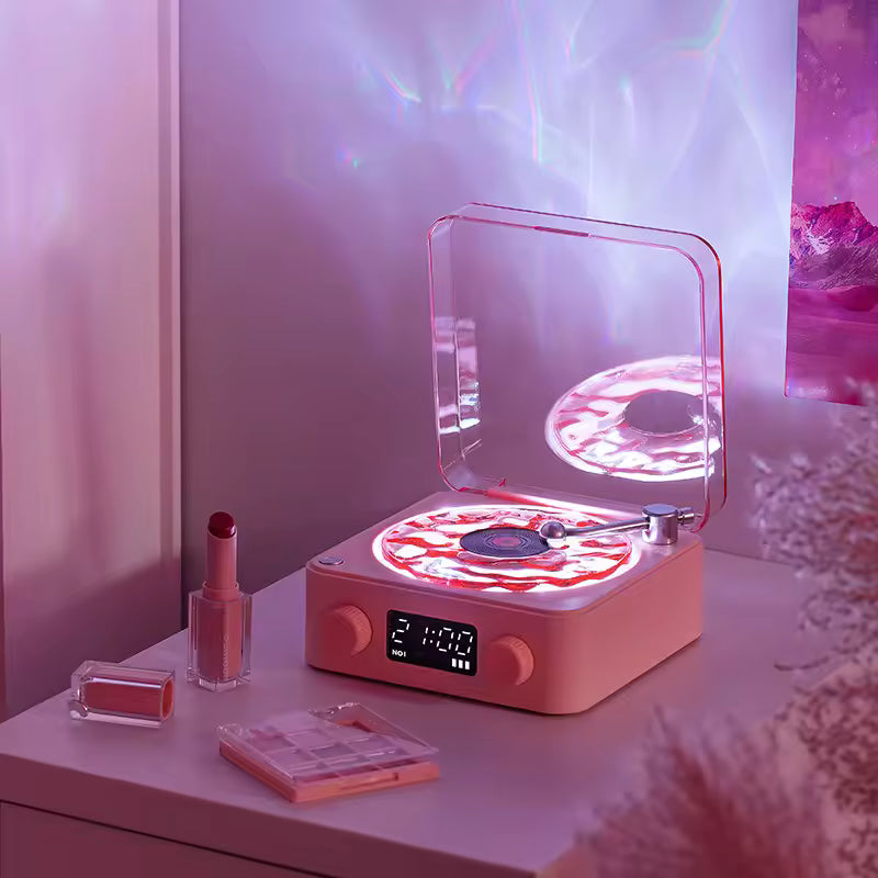 Clarify.pk retro turntable Bluetooth speaker in pink with glowing LED lights and clear dust cover on vanity table