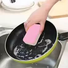 Hand using pink reusable dishcloths for kitchen to clean a green frying pan with soap suds