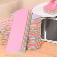 Stack of colorful reusable dishcloths for kitchen placed near sink for easy access