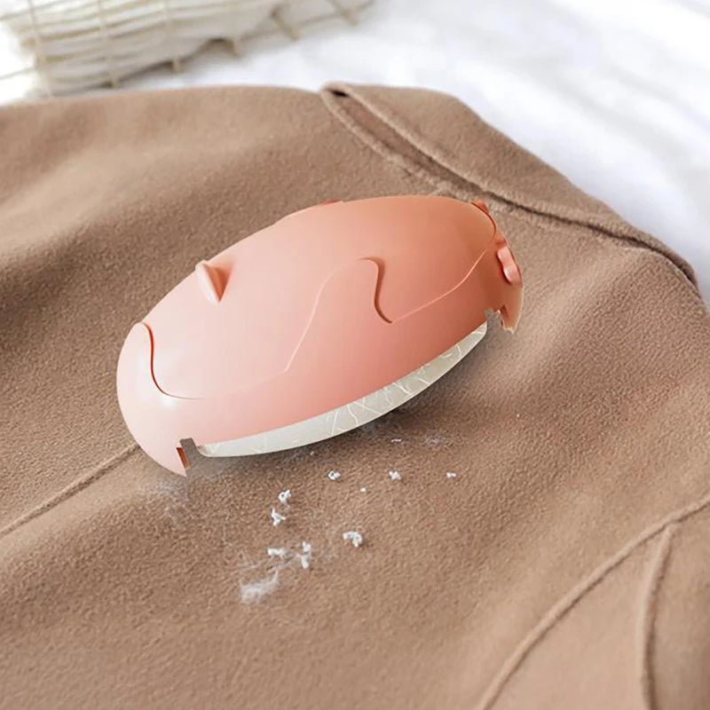 Clarify.pk reusable lint remover in peach used on brown fabric to remove lint and fuzz