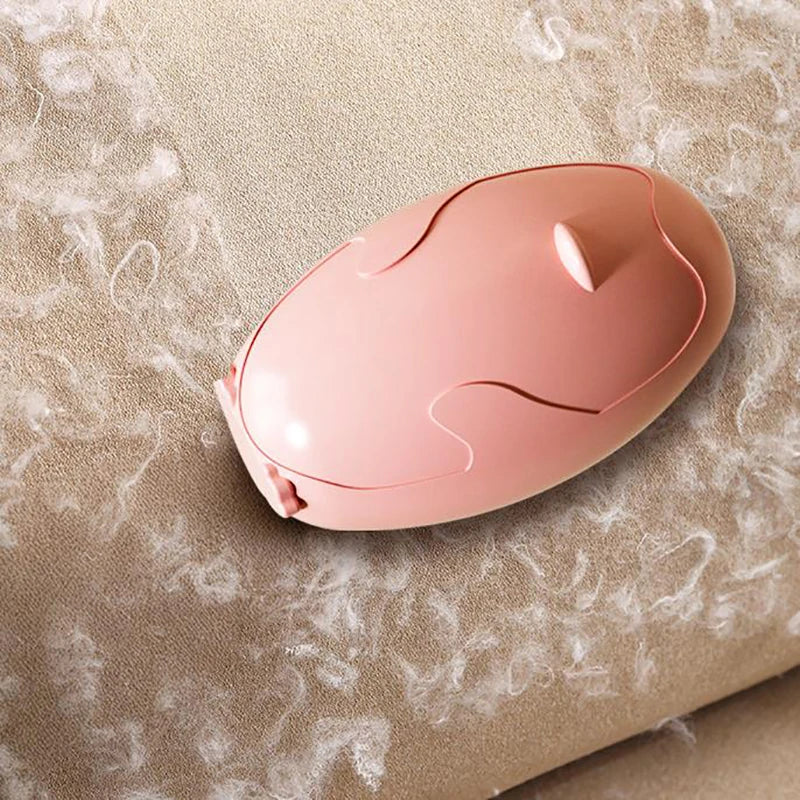 Clarify.pk pink reusable lint remover on beige fabric with visible lint particles