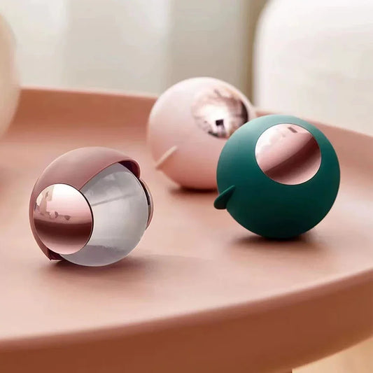 Clarify.pk reusable lint roller ball in green, pink, and mauve colors on a smooth surface