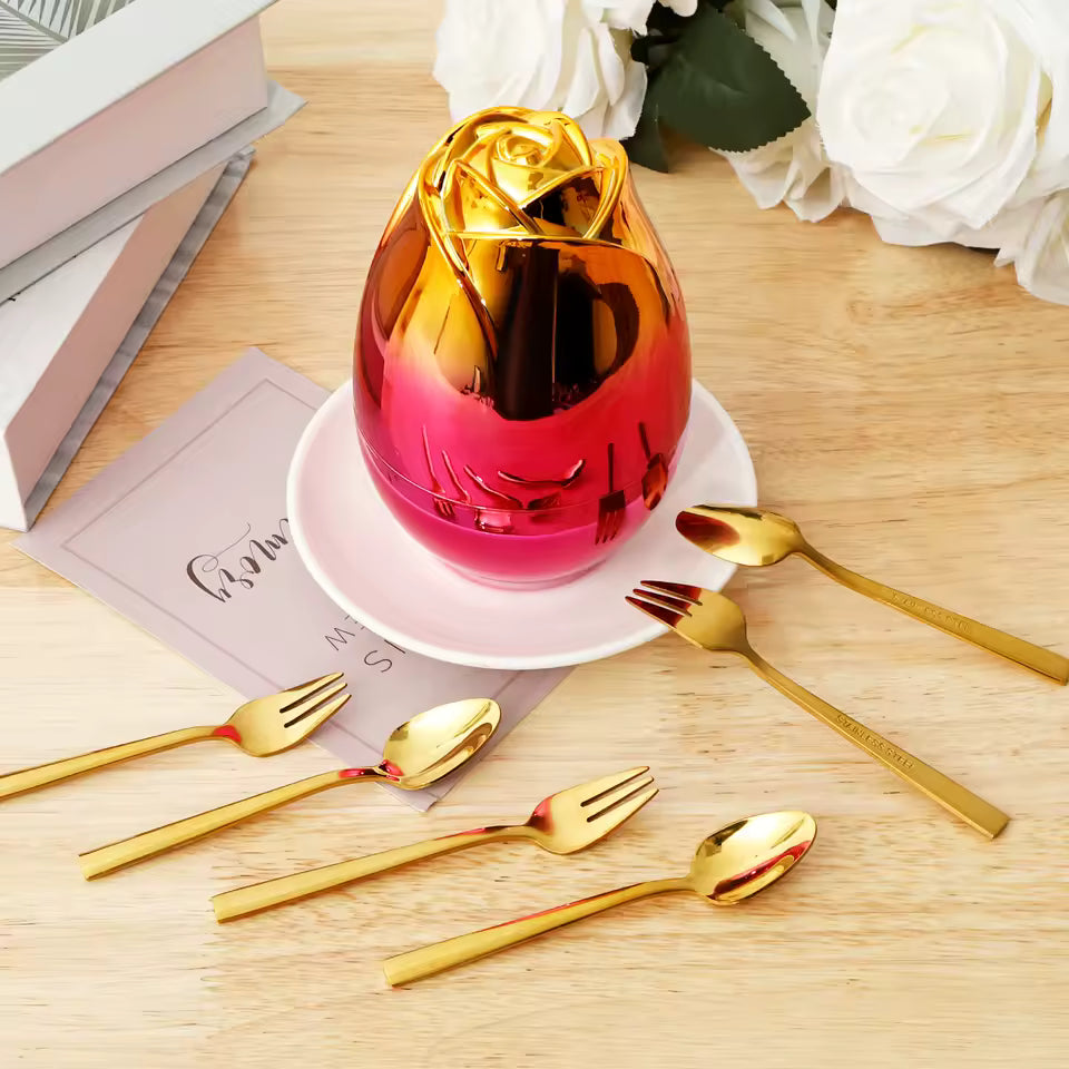 6 piece dinnerware set with case featuring gold utensils and a decorative rose-shaped container on wooden table
