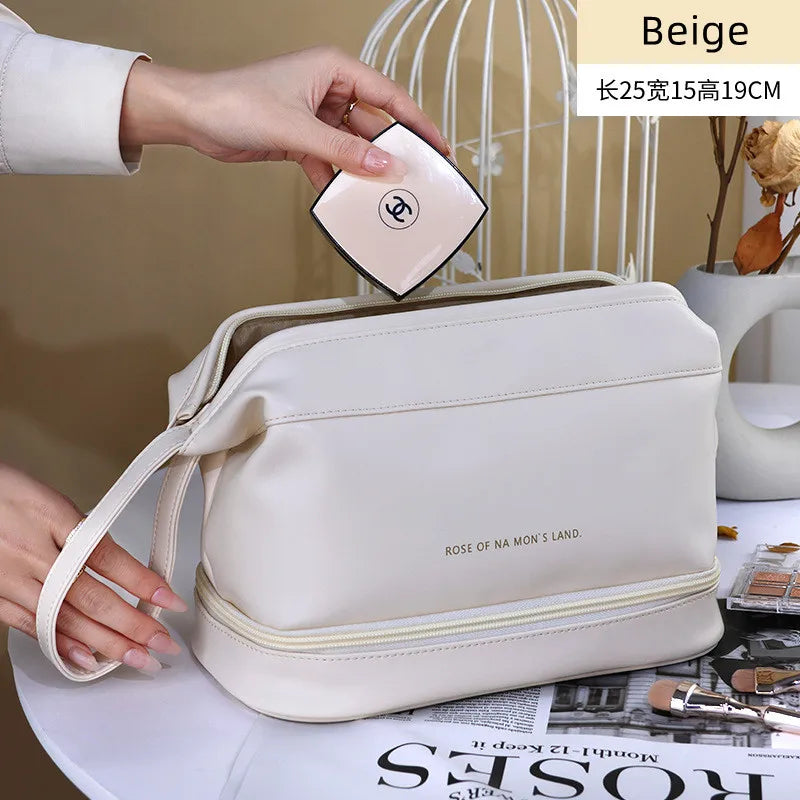 Beige PU leather travel makeup bag with dual compartments placed on a table with cosmetics