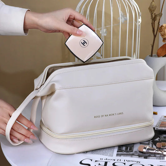 White PU leather travel makeup bag with wrist strap being packed with cosmetic compact