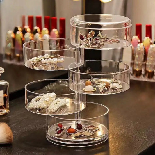 Clear rotating jewelry storage box by Clarify.pk with multiple tiers for organizing earrings and accessories