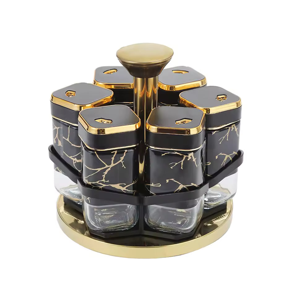Clarify.pk rotating spice jar set with black and gold marble design and clear glass containers on a gold base