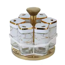 Clarify.pk rotating spice jar set with six hexagonal marble-pattern jars on a gold rotating base