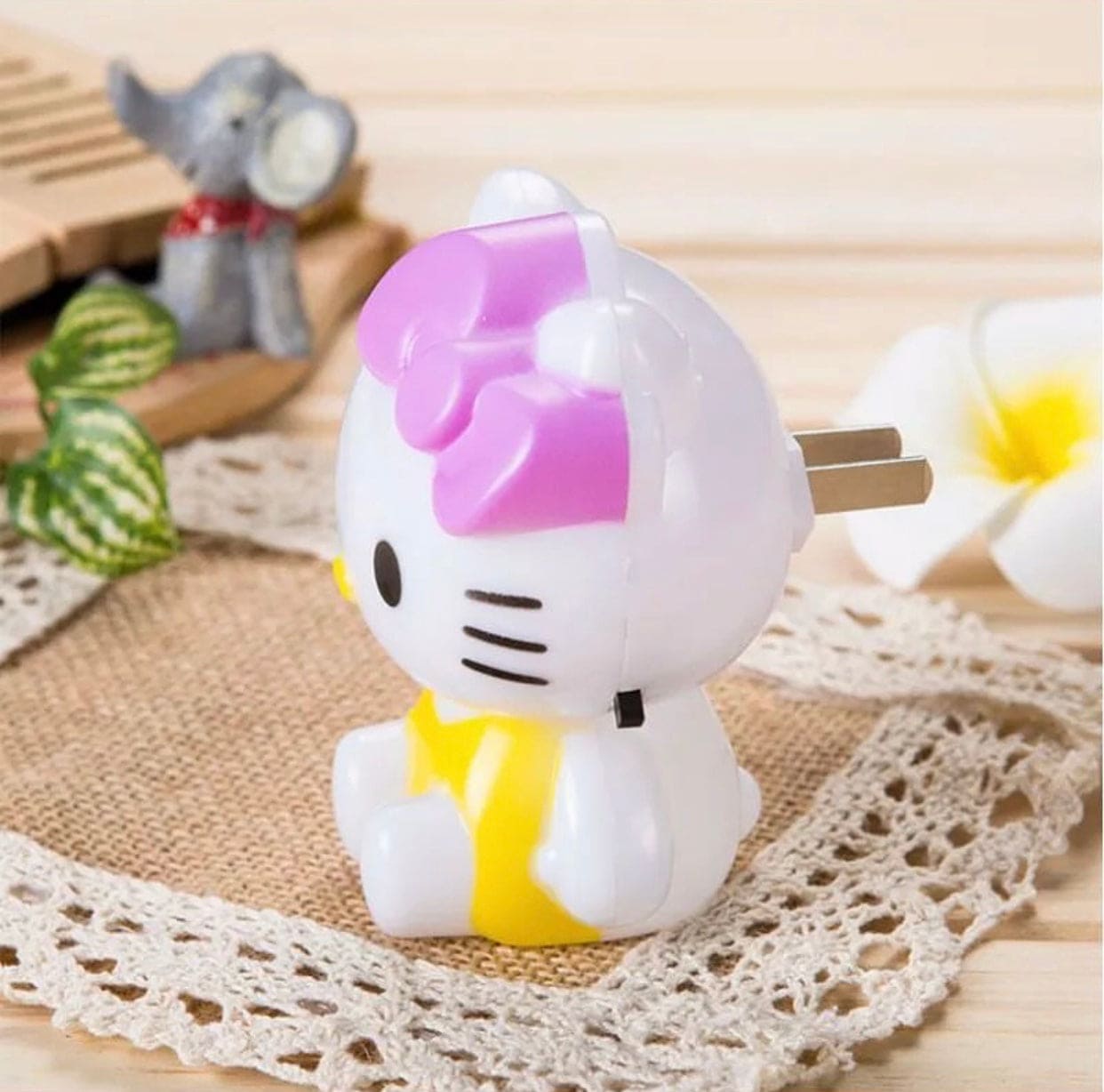 Hello Kitty night light plug-in with pink bow and yellow dress on lace surface by Clarify.pk