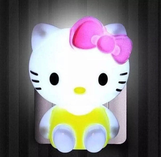 Hello Kitty night light with pink bow and yellow outfit glowing softly on a dark wall