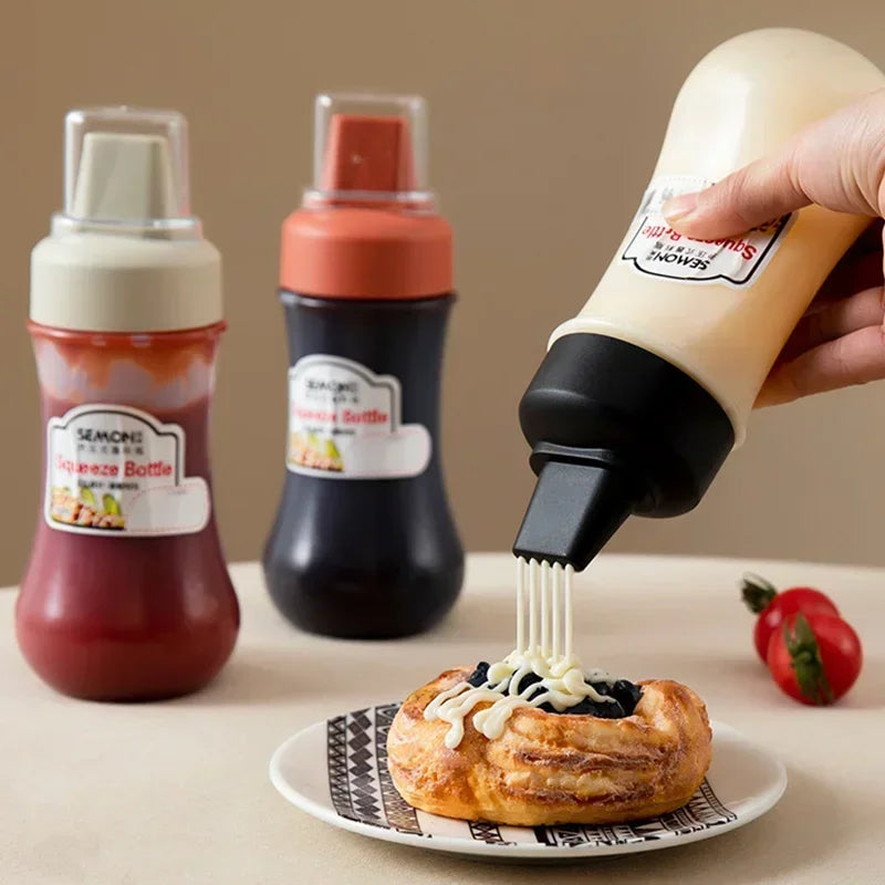 Clarify.pk 350ml sauce squeeze bottle dispensing white sauce over pastry with two other bottles in the background