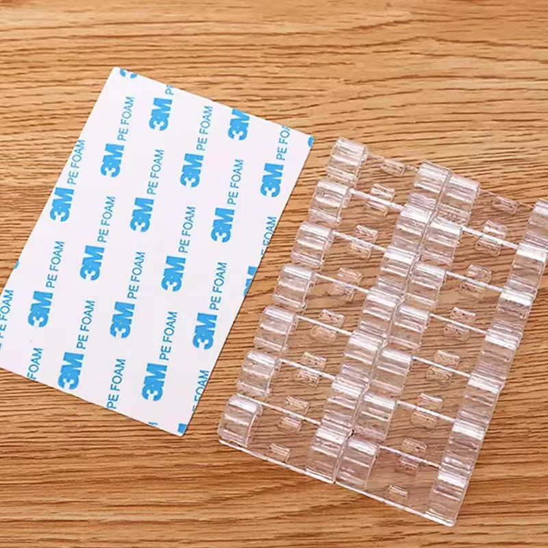 Clarify.pk self adhesive wire holder cable organizer clips with clear adhesive backing on wooden surface