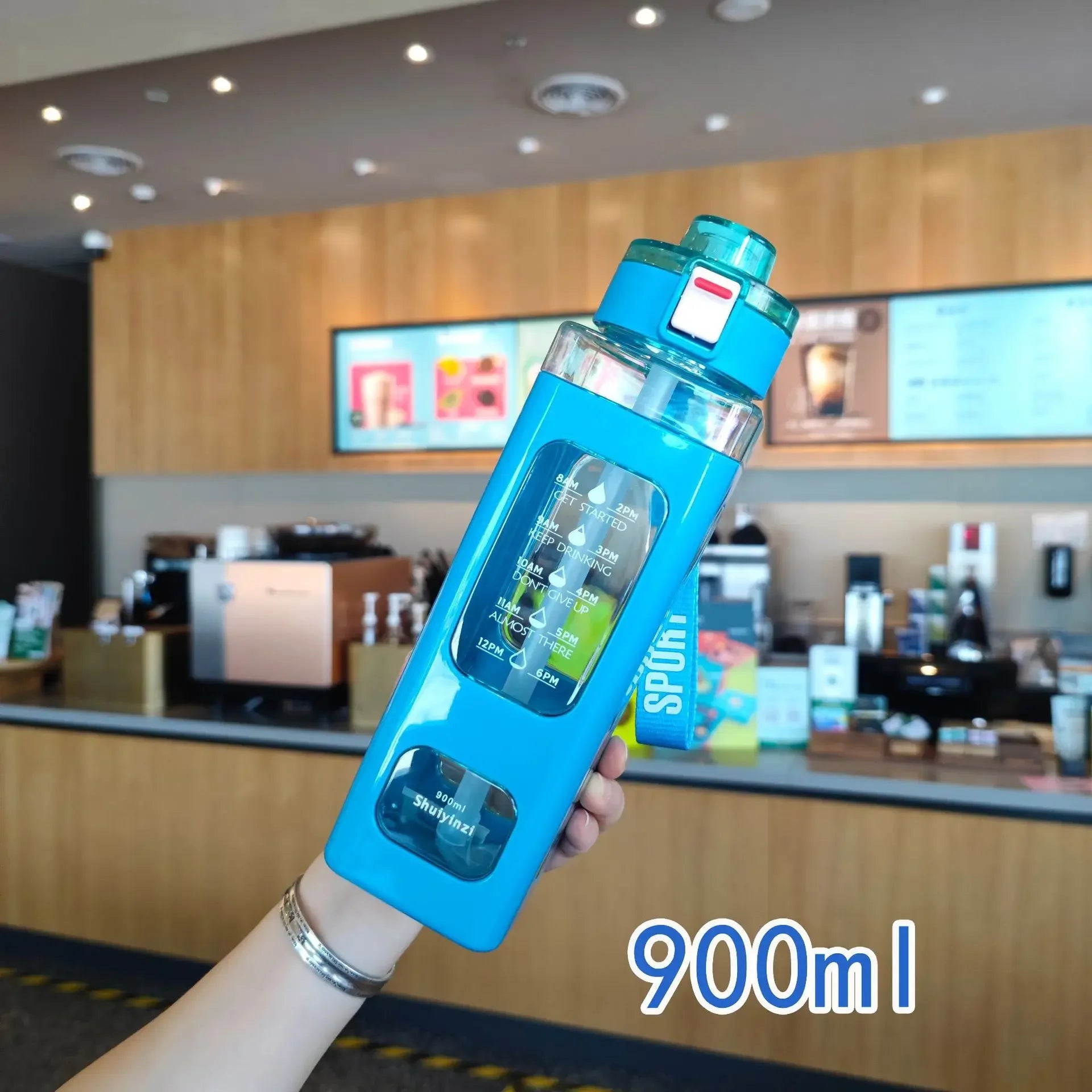 Blue 900ml leak proof water bottle with time marker and secure flip cap held in hand