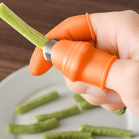 Orange silicone finger protector kitchen tool being used to peel a vegetable with a sharp blade safely