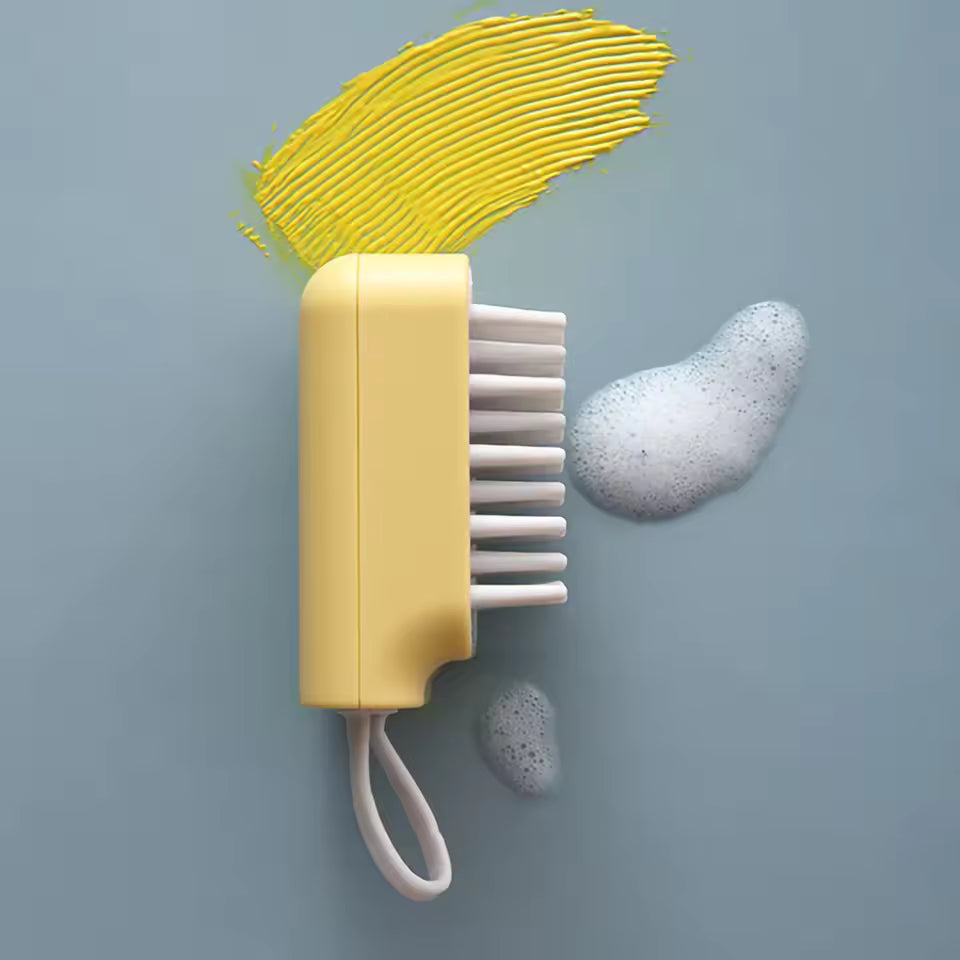 Yellow Clarify.pk silicone head massager brush with soft bristles and soap foam on blue surface