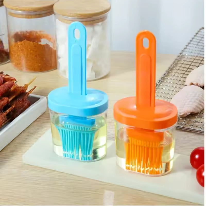 Silicone oil brush for baking with blue and orange handles in clear containers filled with oil
