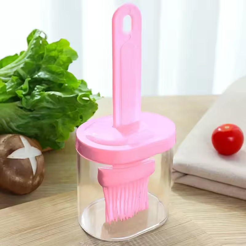 Pink silicone oil brush for baking with clear container from Clarify.pk on wooden surface