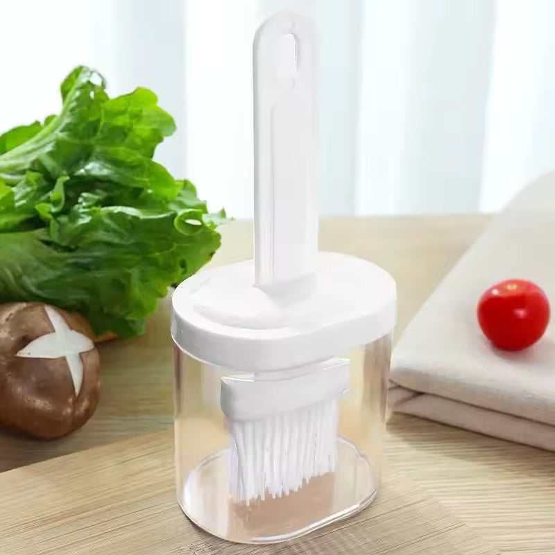 Silicone oil brush for baking with a clear container for oil storage on a wooden surface