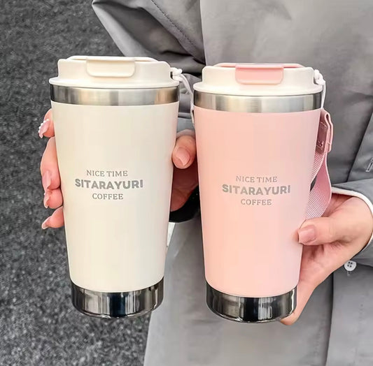 500ml hot and cold water bottle with strap in white and pink held by a person wearing gray jacket