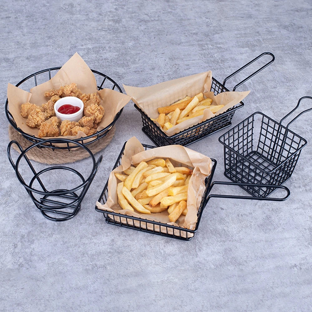 Black metal snack buckets with fries and fried chicken served with ketchup on parchment paper