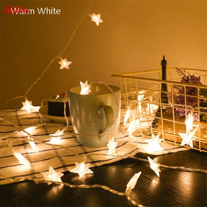Warm white LED star curtain lights for decoration draped over a mug and table with basket