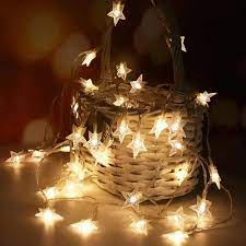 Warm white LED star curtain lights for decoration draped over woven basket in cozy setting