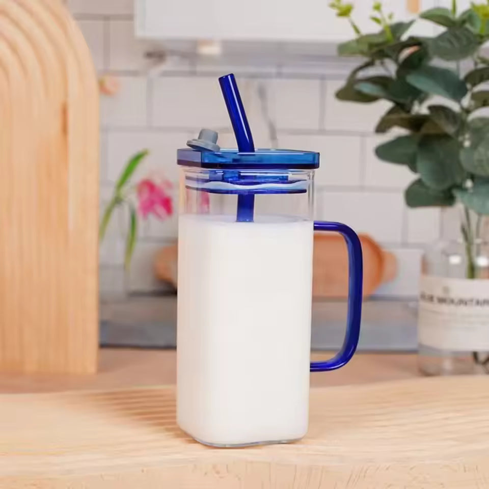 Clarify.pk glass coffee cup with blue lid and straw filled with milk in a transparent glass bottle