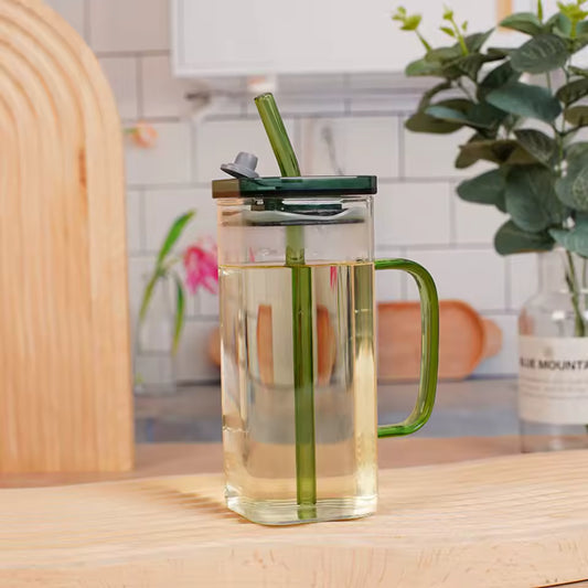 Clarify.pk transparent glass bottle with green handle and lid filled with clear liquid on wooden table