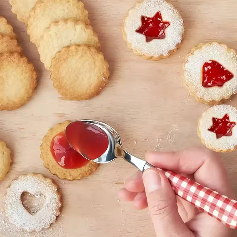 Stainless steel cookie cutters set used to make jam-filled and heart-shaped cookies on wooden surface