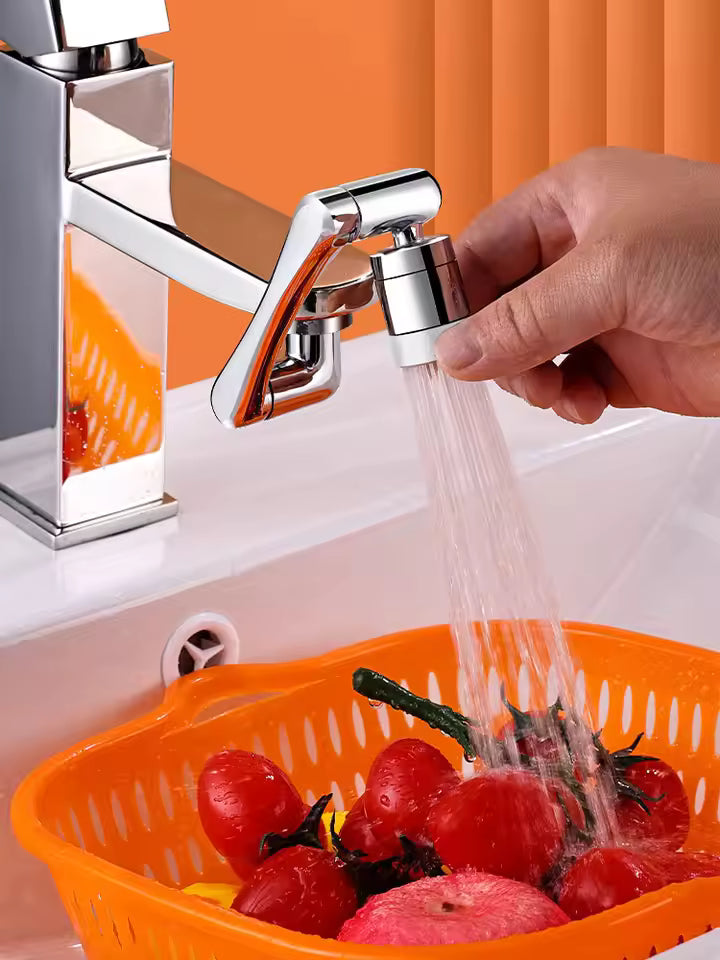 Stainless steel faucet extender attached to sink faucet pouring water on red tomatoes in orange basket