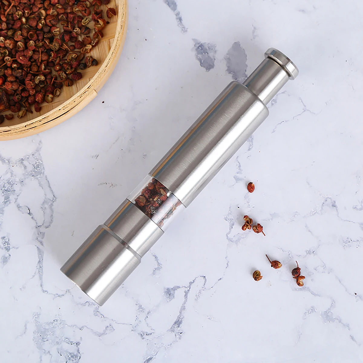 Clarify.pk stainless steel pepper grinder with transparent middle section and modern design on marble surface